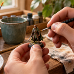Hands painting a miniature medieval knight on a wooden table with paints and brushes nearby.