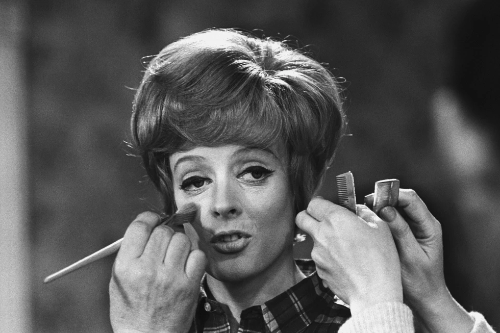 Make up and hair artists add the finishing touches to British actress Maggie Smith before she faces the camera with Peter Ustinov in the comedy ‘Hot Millions’ being filmed at Elstree Studios, England, Jan. 12, 1968. Smith has died aged 89. (AP Photo/Bob Dear, File)